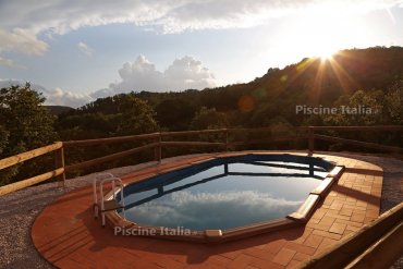 Piscina in acciaio fuori terra Osmose 610: struttura robusta, bordo elegante in mattonelle e vista panoramica sulla natura. Ideale per chi cerca qualità, resistenza e un tocco di design in giardino.