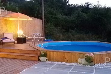 Piscina rotonda in legno fuori terra con bordo deck e solarium: elegante area relax per giardini, struttura robusta in legno massello e installazione veloce.